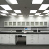 16' x 4 ' laboratory cabinets island. Center shelf centered across black countertop.