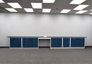 19 ft blue laboratory cabinets with black counter and desk cutout in the middle.