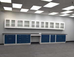 19 feet of blue laboratory cabinets with black countertop and 19 feet of white wall units.