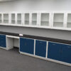 19 feet of blue laboratory cabinets with 19 feet of white wall units. Black counter.