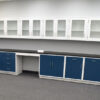 Front view of 19 feet of blue laboratory cabinets with 19 feet of white wall units.