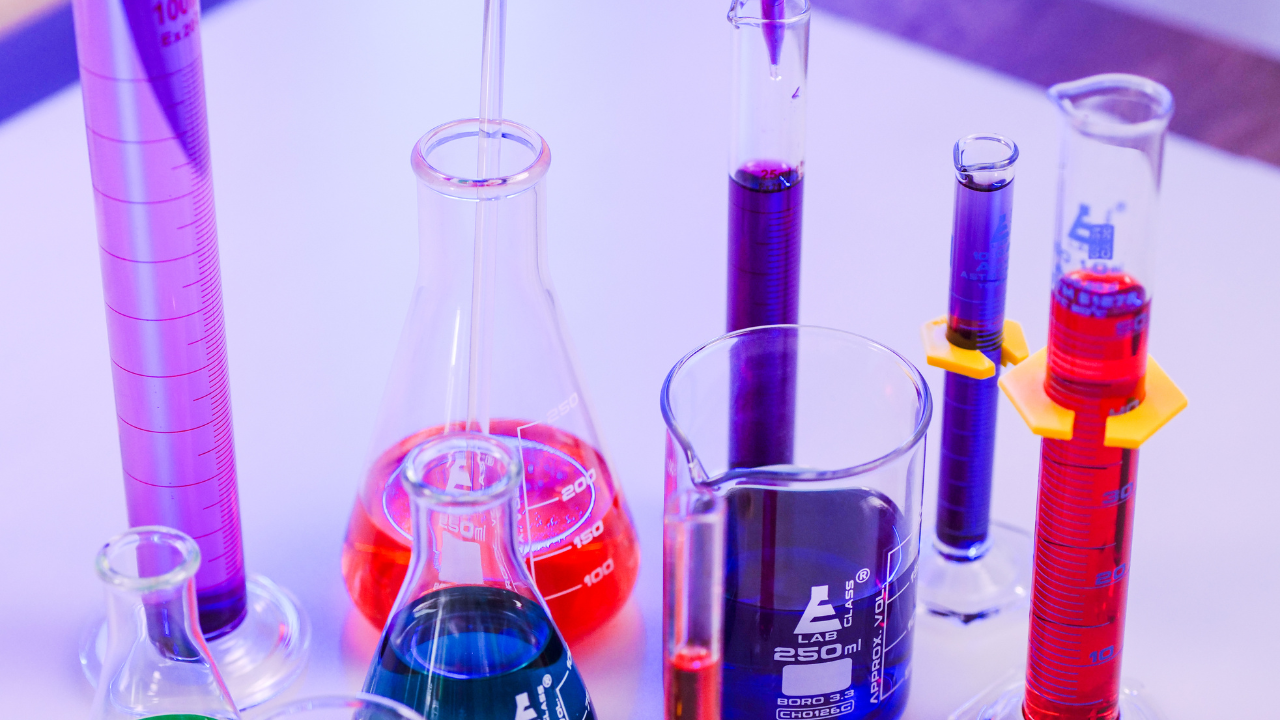 Assortment of laboratory glassware containing brightly colored chemicals.